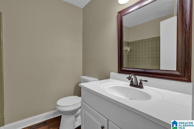 bathroom with vanity, wood-type flooring, and toilet