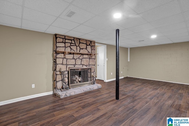 basement with a drop ceiling, a fireplace, and dark hardwood / wood-style flooring