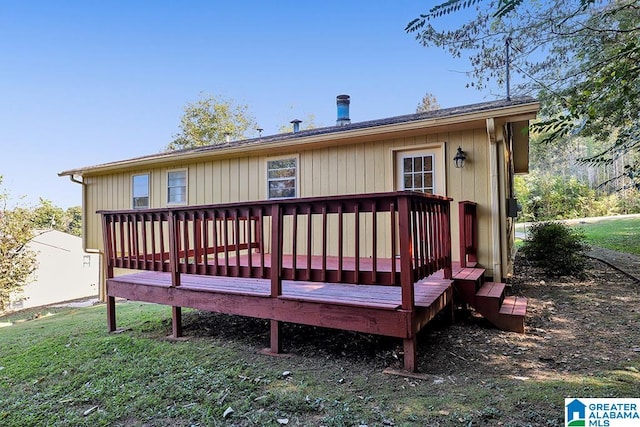 rear view of house with a deck and a lawn