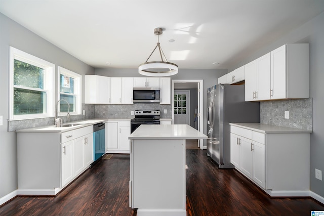 kitchen featuring stainless steel appliances, pendant lighting, a center island, dark hardwood / wood-style floors, and white cabinetry