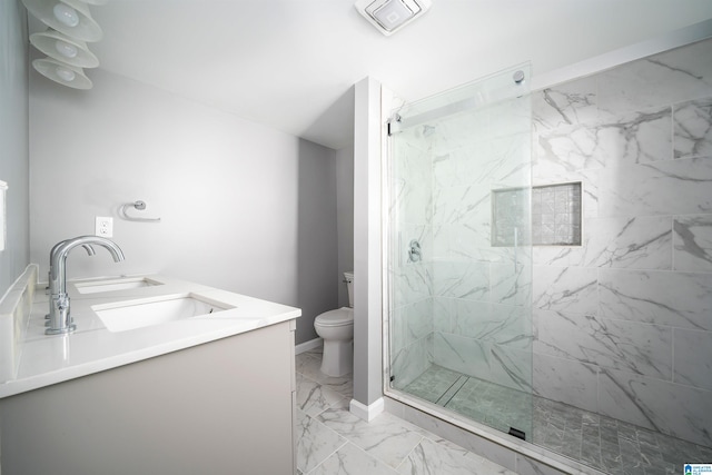 bathroom with vanity, toilet, and tiled shower