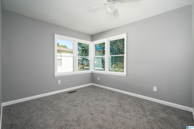 spare room with dark colored carpet and ceiling fan