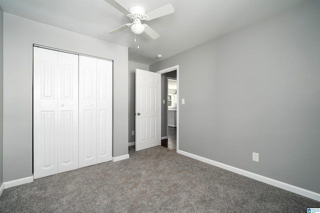 unfurnished bedroom featuring dark colored carpet, a closet, and ceiling fan