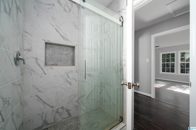 bathroom featuring wood-type flooring and a shower with shower door