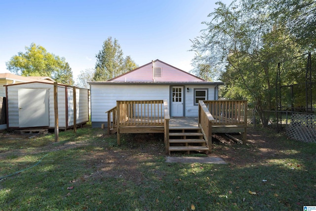 back of property with a wooden deck, a yard, and a shed