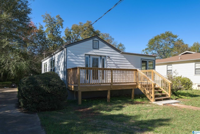 rear view of property with a yard and a wooden deck