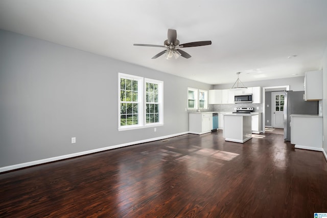 unfurnished living room featuring ceiling fan and dark hardwood / wood-style flooring