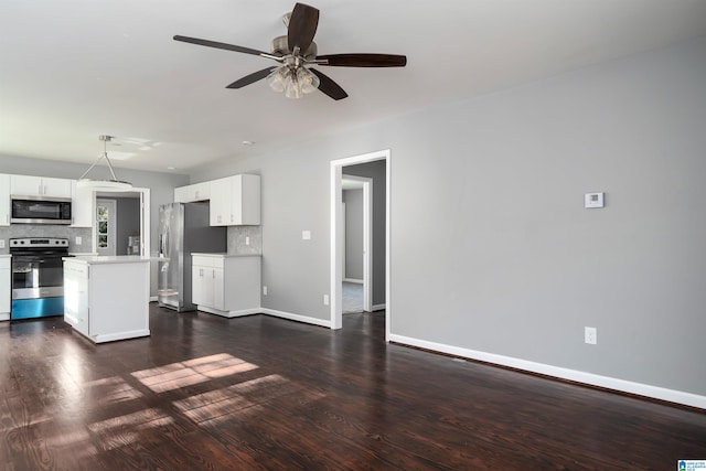 kitchen with backsplash, stainless steel appliances, white cabinetry, and dark hardwood / wood-style floors