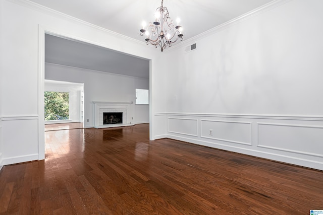 unfurnished living room featuring an inviting chandelier, crown molding, hardwood / wood-style floors, and a fireplace