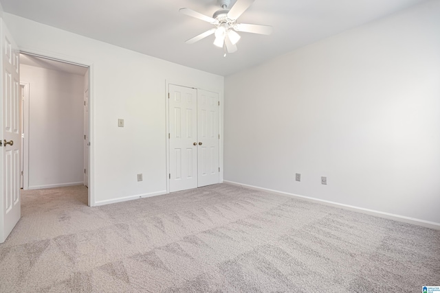 unfurnished bedroom featuring light carpet, a closet, and ceiling fan