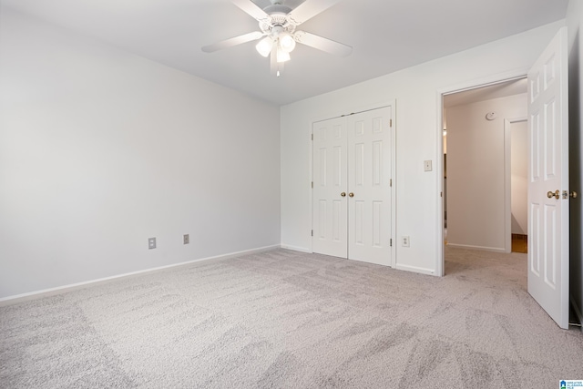 unfurnished bedroom with light colored carpet, a closet, and ceiling fan