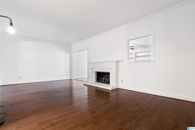 unfurnished living room with crown molding, dark hardwood / wood-style flooring, and a brick fireplace