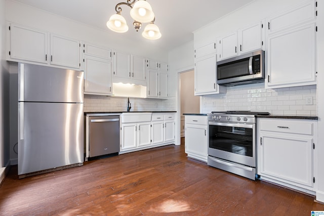 kitchen featuring white cabinetry, stainless steel appliances, dark wood-type flooring, and tasteful backsplash