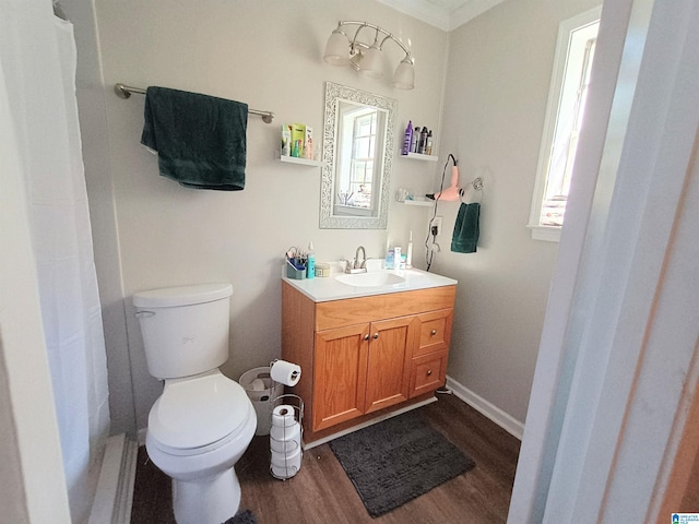 bathroom with wood-type flooring, a shower with shower curtain, toilet, vanity, and crown molding