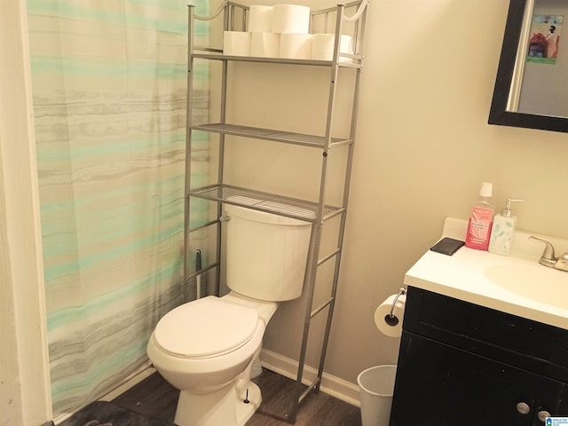 bathroom with toilet, walk in shower, vanity, and hardwood / wood-style flooring