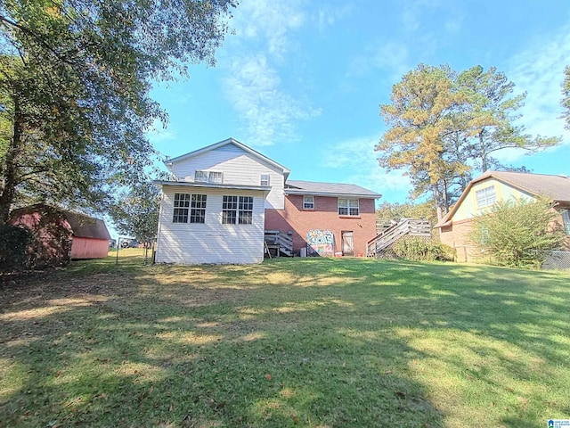 rear view of house featuring a shed and a lawn