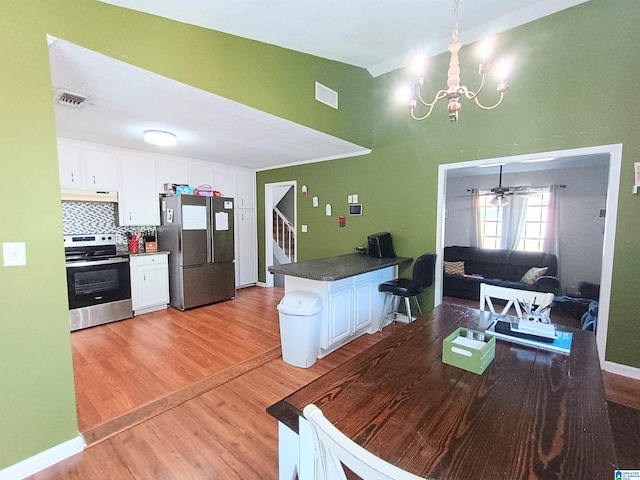 dining area with ceiling fan with notable chandelier and light wood-type flooring