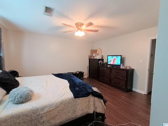 bedroom featuring ceiling fan, a textured ceiling, and dark hardwood / wood-style floors