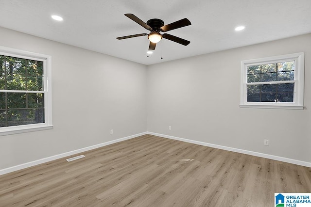 empty room with light wood-type flooring, a healthy amount of sunlight, and ceiling fan