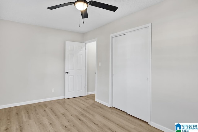 unfurnished bedroom with light hardwood / wood-style flooring, a closet, and ceiling fan