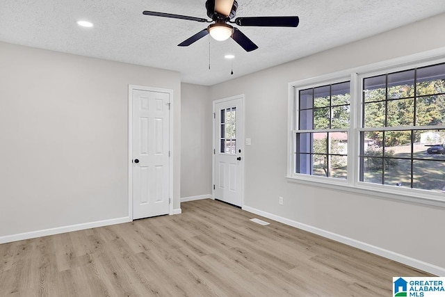 entryway featuring light hardwood / wood-style flooring, a textured ceiling, and ceiling fan