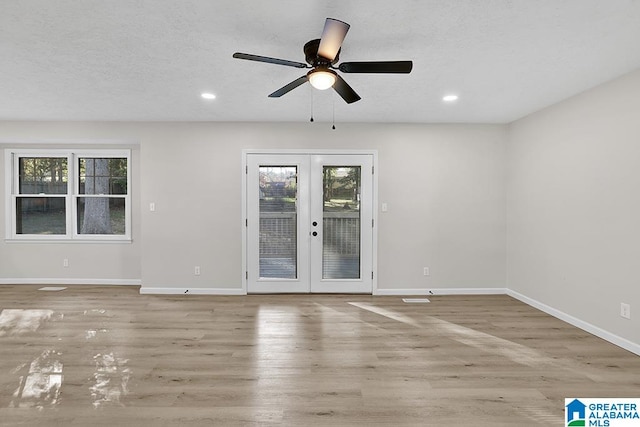 unfurnished room featuring french doors, light hardwood / wood-style flooring, a textured ceiling, and ceiling fan