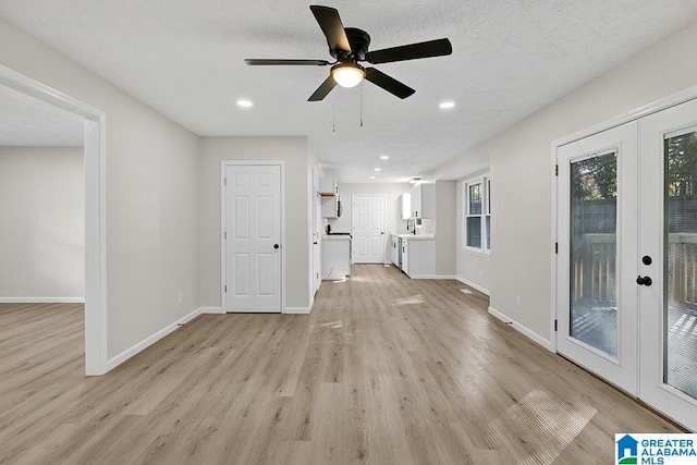 unfurnished living room featuring french doors, a textured ceiling, light wood-type flooring, and ceiling fan