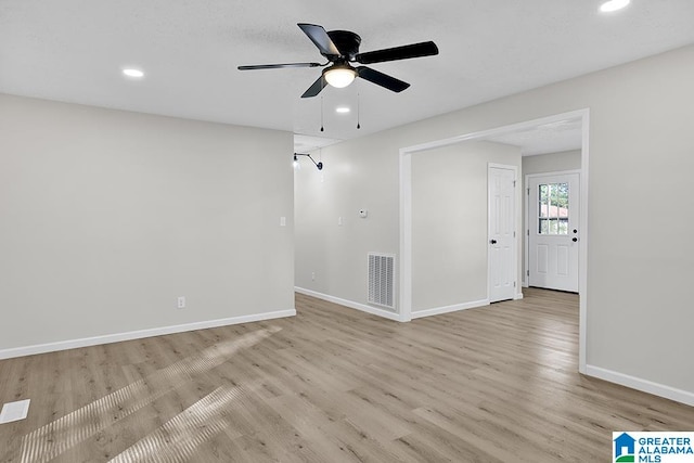 empty room with ceiling fan and light hardwood / wood-style flooring