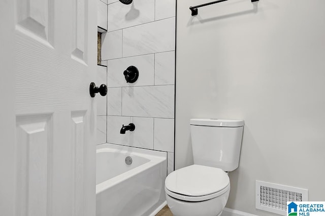 bathroom featuring toilet and tiled shower / bath