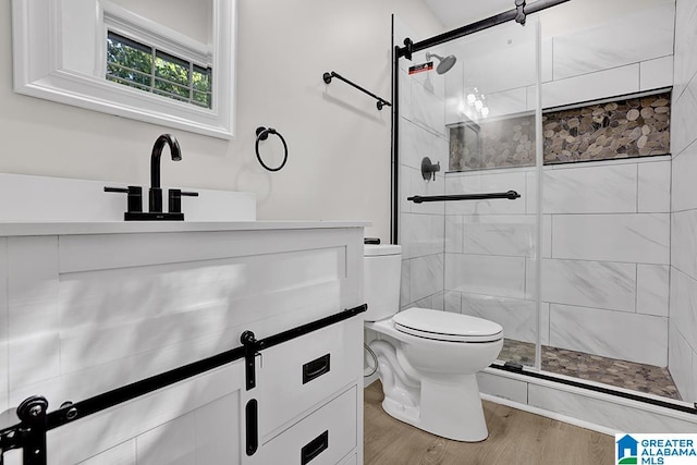 bathroom with vanity, toilet, hardwood / wood-style flooring, and walk in shower