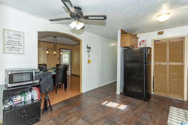 405 Depot St, Columbiana, AL 35051 - kitchen featuring freestanding refrigerator, stainless steel microwave, a ceiling fan, arched walkways, and a textured ceiling