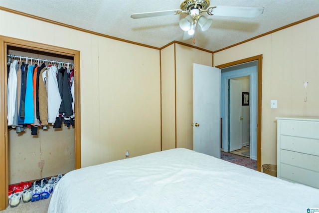 bedroom with ornamental molding, a textured ceiling, ceiling fan, and a closet