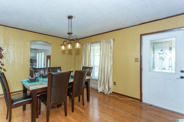 405 Depot St, Columbiana, AL 35051 - dining area featuring a textured ceiling, arched walkways, wood finished floors, ornamental molding, and baseboards