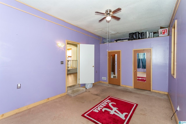 interior space with carpet flooring and ceiling fan