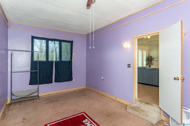 spare room with carpet, a textured ceiling, ornamental molding, and plenty of natural light