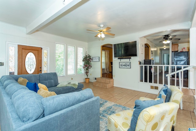 tiled living room with beamed ceiling and ceiling fan