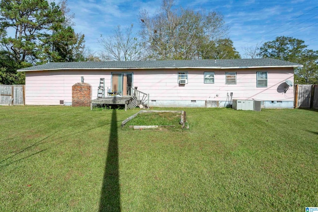 back of property featuring central AC unit and a lawn