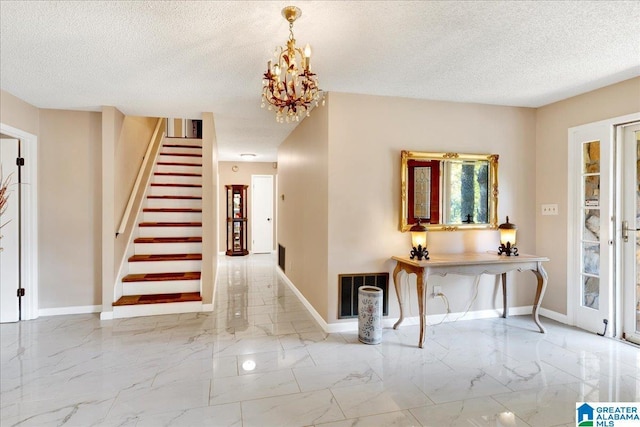 1215 Red Valley Rd, Remlap, AL 35133 - entrance foyer with marble finish floors, a textured ceiling, stairs, baseboards, and a chandelier