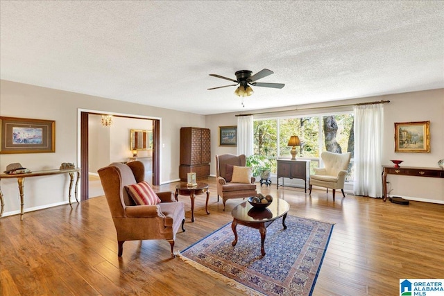 living room with a textured ceiling, hardwood / wood-style flooring, and ceiling fan