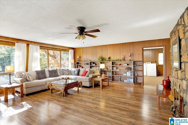 living room featuring washer / dryer, hardwood / wood-style floors, a textured ceiling, and ceiling fan