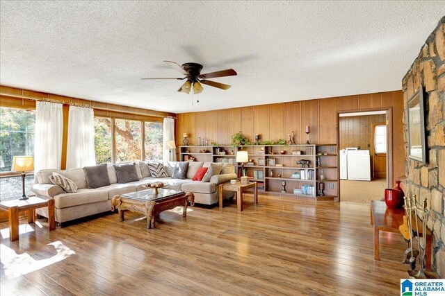 1215 Red Valley Rd, Remlap, AL 35133 - living area featuring a textured ceiling, a ceiling fan, washer / dryer, wood finished floors, and wooden walls