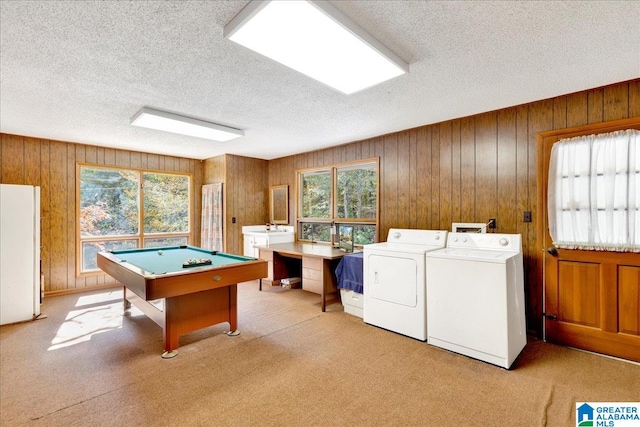 recreation room with washer and dryer, a textured ceiling, light carpet, wooden walls, and billiards