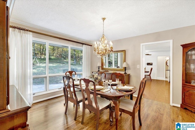 1215 Red Valley Rd, Remlap, AL 35133 - dining room with a chandelier, a textured ceiling, light wood-type flooring, and baseboards