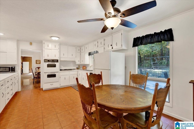 tiled dining space featuring ceiling fan and a textured ceiling