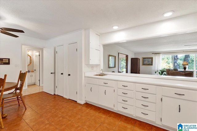 interior space with vanity, tile patterned floors, a textured ceiling, and ceiling fan