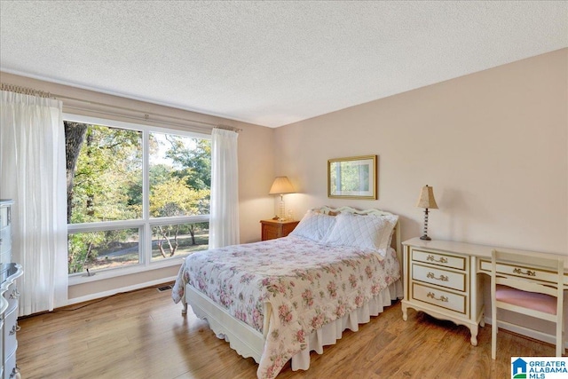 bedroom with a textured ceiling and hardwood / wood-style flooring