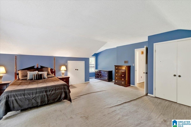 bedroom featuring vaulted ceiling, light carpet, a textured ceiling, and a closet