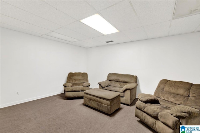 carpeted living room featuring a drop ceiling