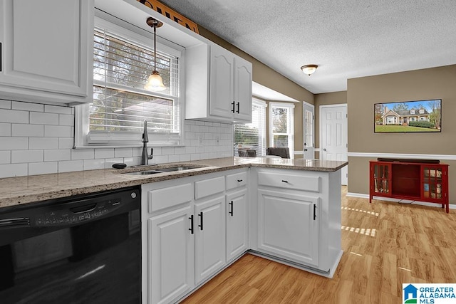 kitchen with black dishwasher, tasteful backsplash, white cabinetry, light wood-type flooring, and sink