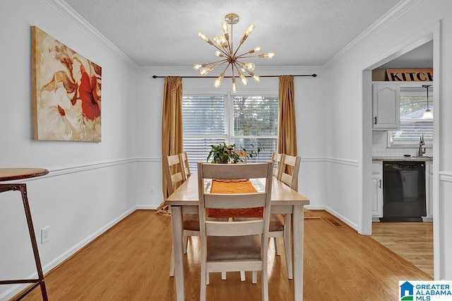 dining space featuring light hardwood / wood-style flooring, a textured ceiling, a chandelier, and crown molding